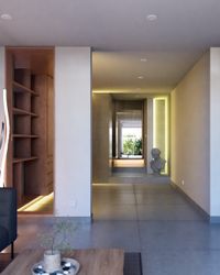 Área de estar con biblioteca integrada de madera y escalera de porcelanato con iluminación LED.