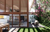Patio moderno con áreas exteriores techadas, celosías y jardines de vivienda contemporánea